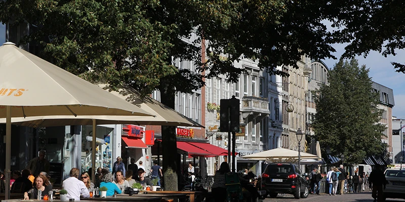 A lane in Aachen's pedestrian zone with shops and outdoor seating