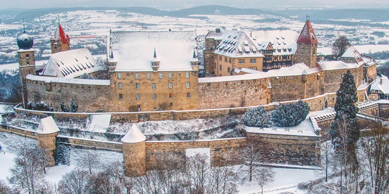 The Veste Coburg fortress on its wooded hill above the town, dusted with winter snow