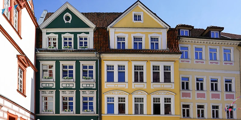A row of colourful gabled merchant houses in green, yellow and cream on the Coburg market square