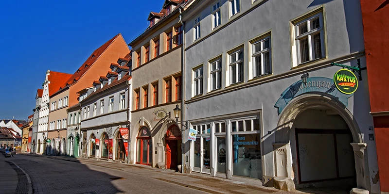 A street of shops in Naumburg with an archway and painted facades