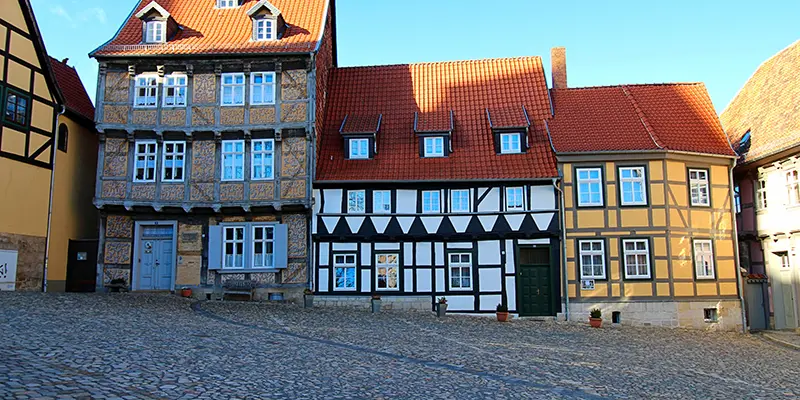 A cobbled square below the castle lined with grand decorated timber houses