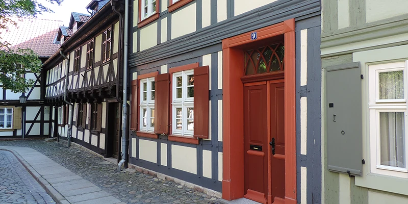 Quiet cobbled lane in Wernigerode lined with half-timbered houses, a red-painted door numbered 9