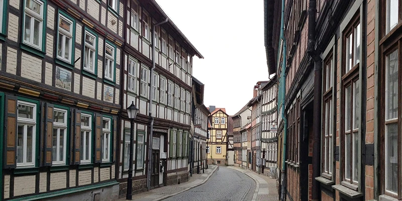 Empty cobbled side street in Wernigerode curving between rows of timber-framed houses