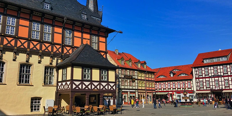Wernigerode market square on a sunny day, with the Town Hall, café tables, a fountain and gabled houses