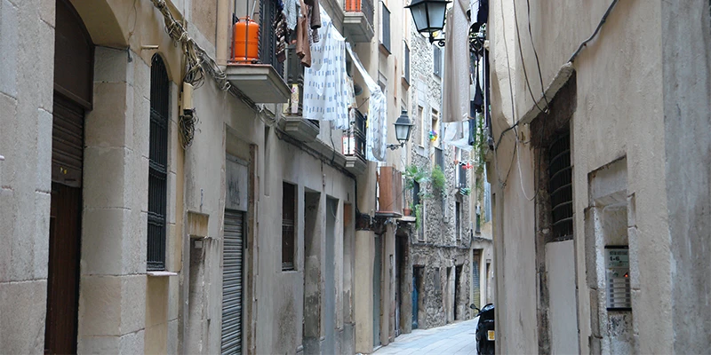 Narrow medieval alley near Plaça Sant Cugat with historic stone buildings