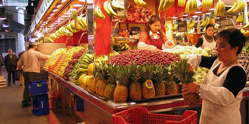 Merchants arranging colorful displays at Boqueria market