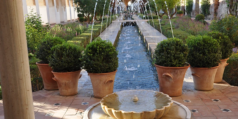 Cypress-lined stairways with water running down stone balustrades in the Generalife upper gardens