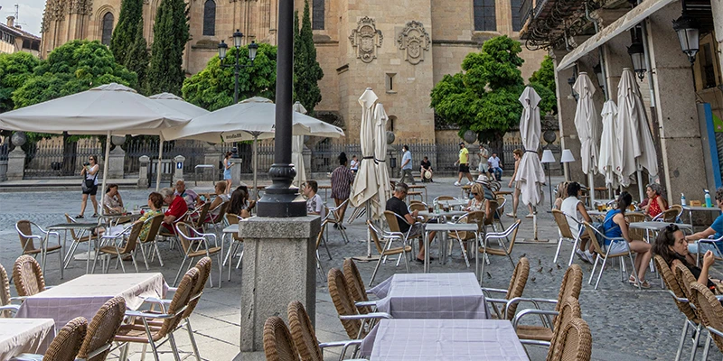 Terrace cafes filling with locals on the Plaza Mayor under the arcaded buildings