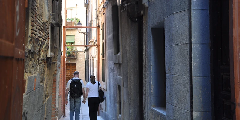 Atmospheric narrow alley in Toledo barely wide enough for two people